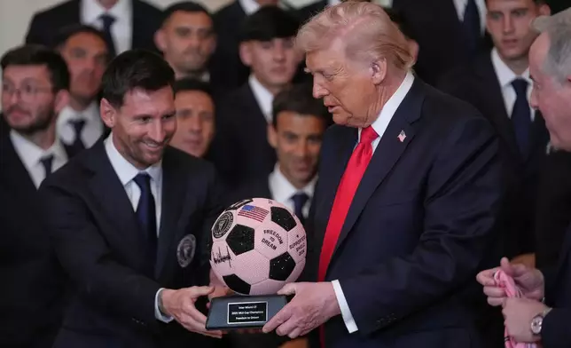 President Donald Trump receives a soccer ball trophy from Lionel Messi during an event to honor the 2025 Major League Soccer champions Inter Miami in the East Room of the White House, Thursday, March 5, 2026, in Washington. (AP Photo/Julia Demaree Nikhinson)