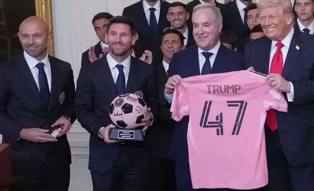 President Donald Trump poses for a photo as head coach Javier Mascherano, Lionel Messi and Inter Miami co-owner Jorge Mas present gifts at an event to honor the 2025 Major League Soccer champions Inter Miami in the East Room of the White House, Thursday, March 5, 2026, in Washington. (AP Photo/Julia Demaree Nikhinson)