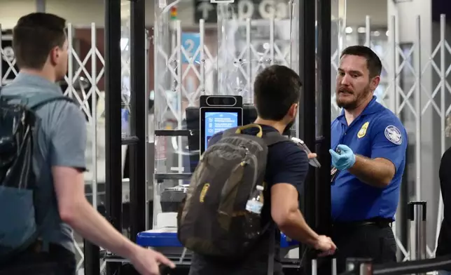 A TSA staff member at a check point at Harry Reid International Airport, Saturday, March 21, 2026, in Las Vegas. (AP Photo/Ty ONeil)