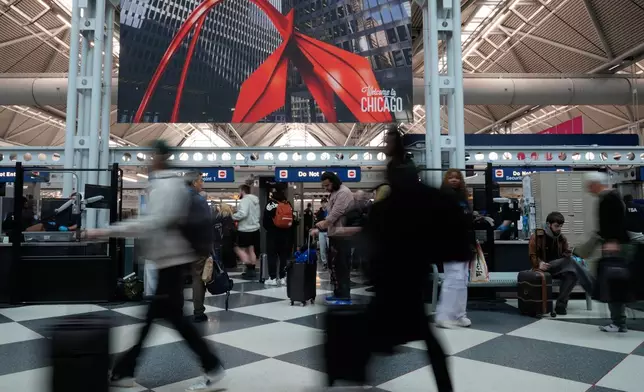 Travelers go through TSA security check at O'Hare International Airport, Saturday, March 21, 2026, in Chicago. (AP Photo/Kiichiro Sat0)