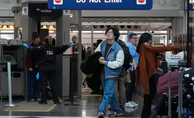Travelers go through TSA security check at O'Hare International Airport, Saturday, March 21, 2026, in Chicago. (AP Photo/Kiichiro Sat0)