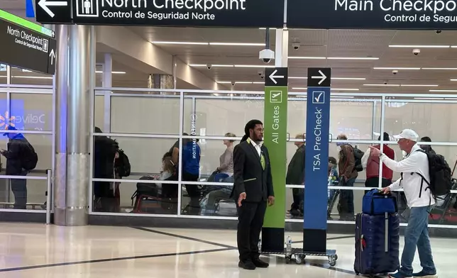 Passengers wait outside a Transportation Security Administration checkpoint at Hartsfield-Jackson Atlanta International Airport on Saturday, March, 21, 2026, (AP Photo/Jeff Amy)