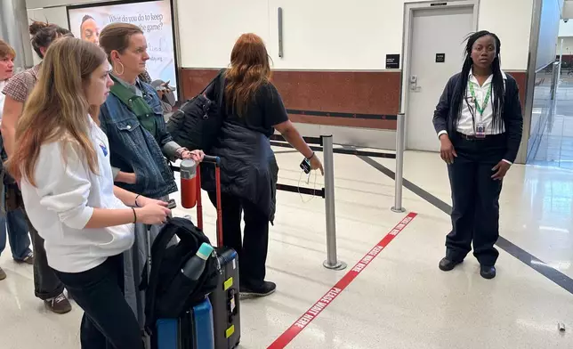 Passengers wait outside a Transportation Security Administration checkpoint at Hartsfield-Jackson Atlanta International Airport on Saturday, March, 21, 2026, (AP Photo/Jeff Amy)