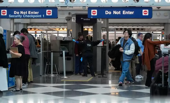 Travelers go through TSA security check at O'Hare International Airport, Saturday, March 21, 2026, in Chicago. (AP Photo/Kiichiro Sat0)