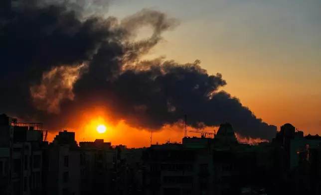 The sun sets behind a plume of smoke rising after a U.S.–Israeli military strike in Tehran, Iran, Tuesday, March 3, 2026. (AP Photo/Vahid Salemi)