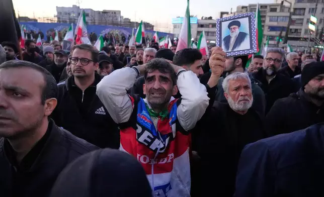Government supporters mourn during a gathering after state TV officially announced the death of Iranian Supreme Leader Ayatollah Ali Khamenei, shown in the poster, in Tehran, Iran, Sunday, March 1, 2026. (AP Photo/Vahid Salemi)
