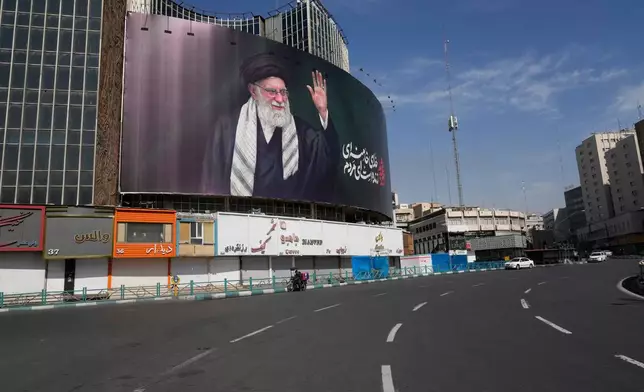A billboard showing a portrait of the late Iranian Supreme Leader Ayatollah Ali Khamenei, who was killed in U.S.-Israeli strikes, looms over an empty square in Tehran, Iran, Thursday, March 5, 2026. (AP Photo/Vahid Salemi)