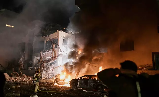 Firefighters try to extinguish flames in a building after a direct hit by an Iranian missile strike in Tel Aviv, Israel, Saturday, Feb. 28, 2026. (AP Photo/Tomer Neuberg)
