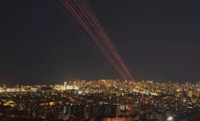 Tracer rounds light the sky as people fire live rounds into the air during a televised speech by Hezbollah leader Naim Kassem in Dahiyeh, Beirut's southern suburbs, Lebanon, Wednesday, March 4, 2026. (AP Photo/Hassan Ammar)
