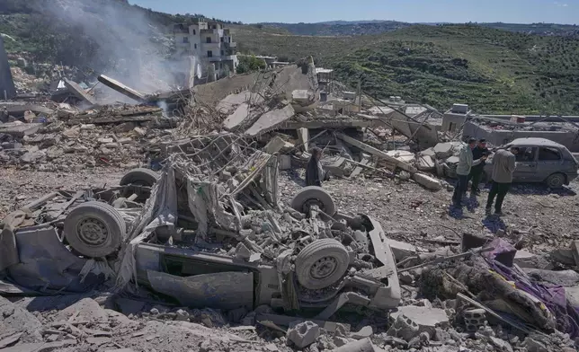 People check the site where Israeli airstrikes hit several houses in Sir al-Gharbiyeh village south Lebanon, Sunday, March, 8, 2026. (AP Photo/Mohammed Zaatari)