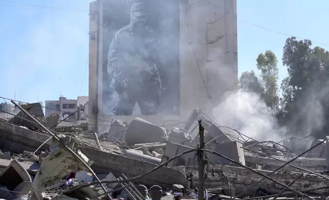 A giant poster shows the late Hezbollah military commander Imad Mughniyeh, behind a destroyed building that was hit by an Israeli airstrike in Nabatiyeh town, south Lebanon, Thursday, March 5, 2026. (AP Photo/Mohammed Zaatari)