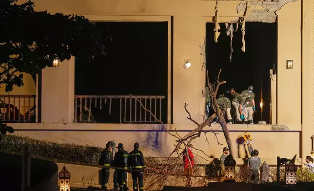 Firemen and rescue workers inspect the site of an explosion at the Fairmont The Palm Hotel in Dubai, United Arab Emirates, Saturday, Feb. 28, 2026. (AP Photo/Altaf Qadri)