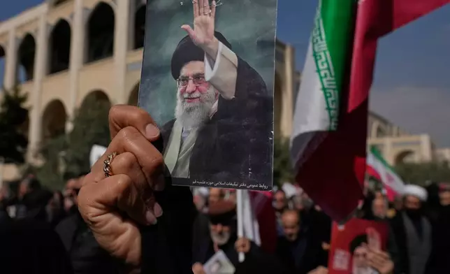 A woman holds up a picture of the late Iranian Supreme Leader Ayatollah Ali Khamenei as government supporters march against the ongoing U.S.-Israeli military campaign after Friday prayers at the Imam Khomeini Grand mosque in Tehran, Iran, Friday, March 6, 2026. (AP Photo/Vahid Salemi)