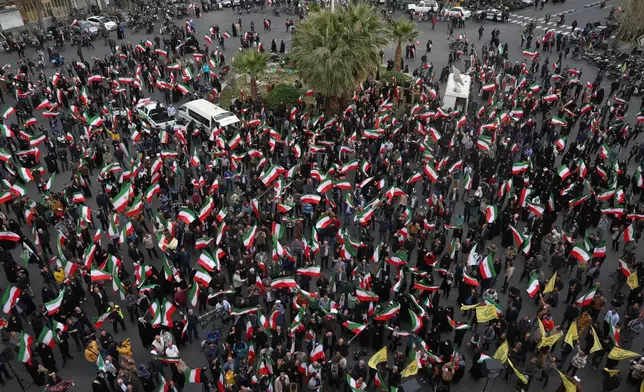 A group of demonstrators wave Iranian flags in support of the government and against U.S. and Israeli strikes in Tehran, Iran, Saturday, Feb. 28, 2026. (AP Photo/Vahid Salemi)