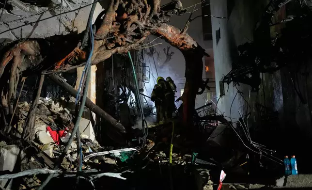 Officers from Israel's Home Front Command search through the rubble of a damaged apartment building after an Iranian missile strike in Tel Aviv, Israel, early Sunday, March 1, 2026. (AP Photo/Ohad Zwigenberg)