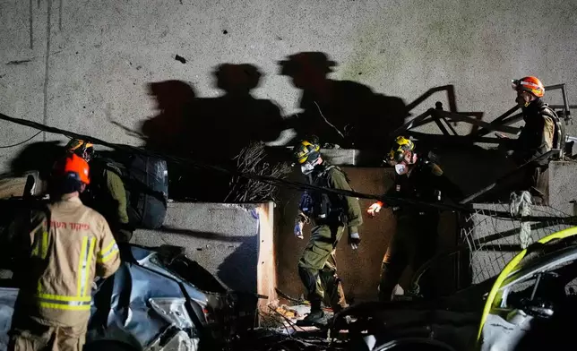 Officers from Israel's Home Front Command search through the rubble of a damaged apartment building after an Iranian missile strike in Tel Aviv, Israel, Saturday, Feb. 28, 2026. (AP Photo/Ohad Zwigenberg)