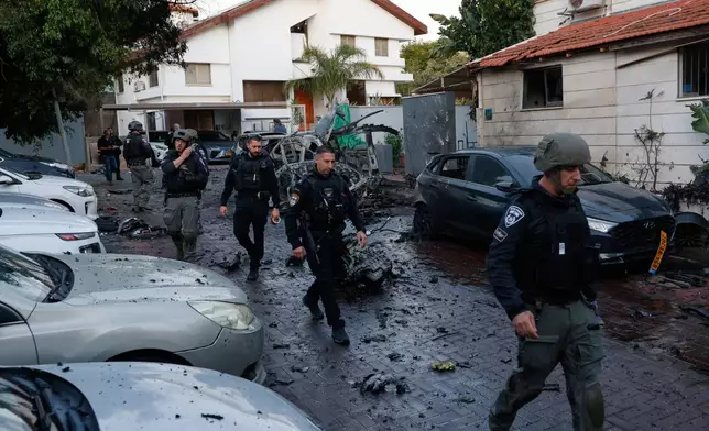 ***ISRAEL OUT***Israeli policemen survey a missile attack from Iran in Rosh HaAyin, Israel, Saturday, Feb. 28, 2026. (AP Photo/Tomer Appelbaun)***ISRAEL OUT***
