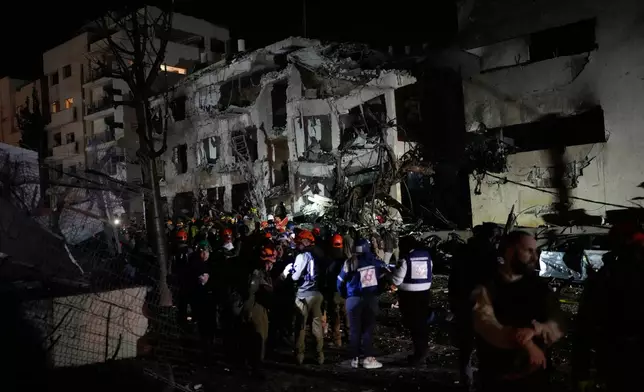 Israeli rescue personal search through the rubble of a damaged apartment building after an Iranian missile strike in Tel Aviv, Israel, Saturday, Feb. 28, 2026. (AP Photo/Ohad Zwigenberg)