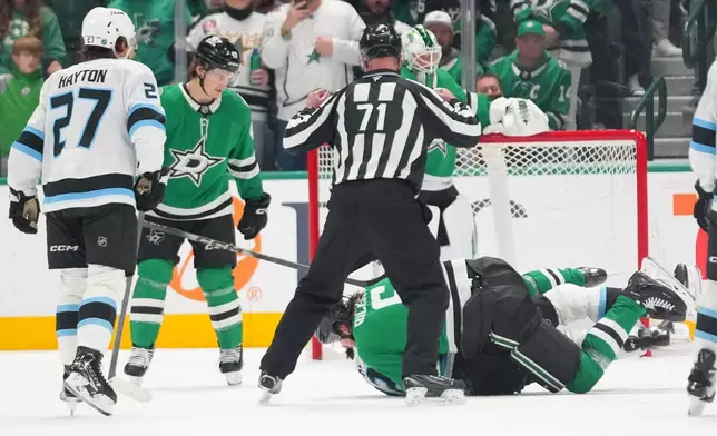 Dallas Stars defenseman Lian Bichsel, bottom, fights with Utah Mammoth center Jack McBain during the first period of an NHL hockey game Monday, March 16, 2026, in Dallas. (AP Photo/Julio Cortez)