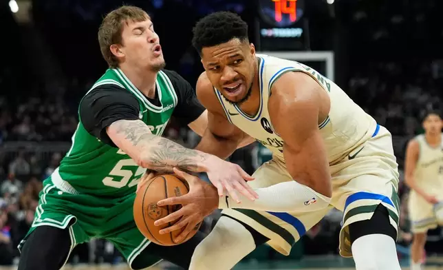 Boston Celtics' Baylor Scheierman, left, strips the ball from Milwaukee Bucks' Giannis Antetokounmpo during the first half of an NBA basketball game, Monday, March 2, 2026, in Milwaukee. (AP Photo/Aaron Gash)
