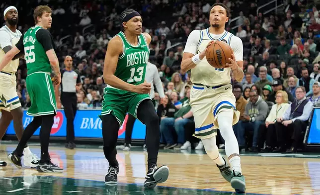 Milwaukee Bucks' Ryan Rollins, right, drives to the basket against Boston Celtics' Ron Harper Jr. during the first half of an NBA basketball game, Monday, March 2, 2026, in Milwaukee. (AP Photo/Aaron Gash)