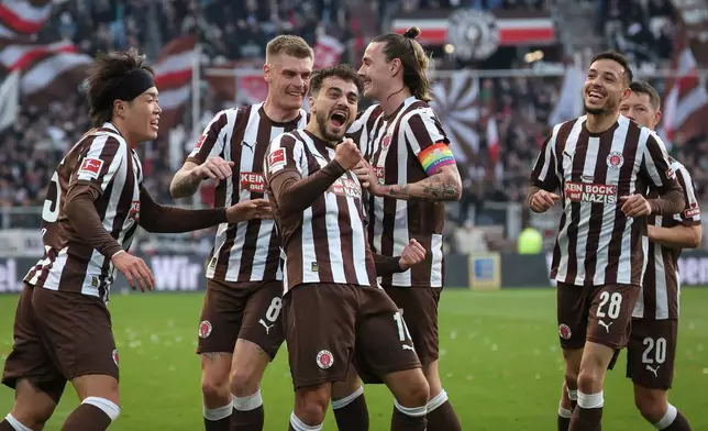 St. Pauli's Danel Sinani, front center, celebrates after scoring the opening goal during the German Bundesliga soccer match between FC St. Pauli and SC Freiburg in Hamburg, Germany, Sunday, March 22, 2026. (Christian Charisius/dpa via AP)