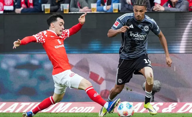 Mainz' Paul Nebel, left, and Frankfurt's Jean-Matteo Bahoya, right, challenge for the ball during the German Bundesliga soccer match between 1.FSV Mainz 05 and Eintracht Frankfurt in Mainz, Germany, Sunday, March 22, 2026. (Marc Schueler/dpa via AP)