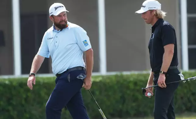 Shane Lowry of Ireland talks to Jimmy Stanger on the 17 green during the third round of the Cognizant Classic golf tournament, Saturday, Feb. 28, 2026, in Palm Beach Gardens, Fla. (AP Photo/Marta Lavandier)