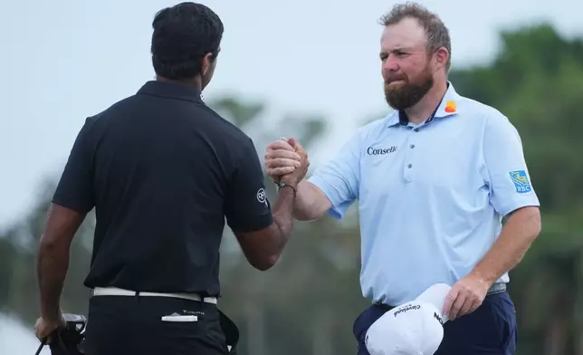 Shane Lowry of Ireland shakes hands with Aaron Rai of England, at the end of the third round of the Cognizant Classic golf tournament, Saturday, Feb. 28, 2026, in Palm Beach Gardens, Fla. (AP Photo/Marta Lavandier)