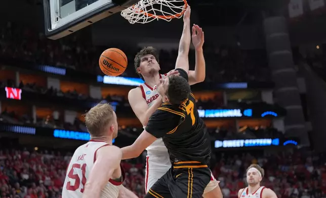 Iowa forward Alvaro Folgueiras (7) dunks over Nebraska forward Berke Buyuktuncel (9) during the second half in the Sweet 16 of the NCAA college basketball tournament Thursday, March 26, 2026, in Houston. (AP Photo/Eric Gay)