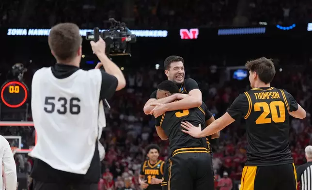 Iowa forwards Alvaro Folgueiras, rear, Cam Manyawu (3) and forward Trey Thompson (20) celebrate after defeating Nebraska in the Sweet 16 of the NCAA college basketball tournament Thursday, March 26, 2026, in Houston. (AP Photo/Eric Gay)