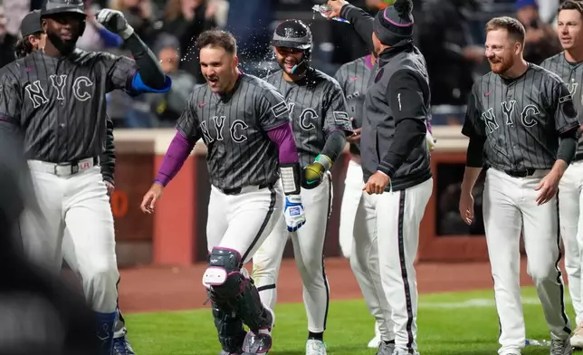New York Mets shortstop Bo Bichette (19) celebrates with teammates after scoring during the eleventh inning of a baseball game against the Pittsburgh Pirates, Saturday, March 28, 2026, in New York. (AP Photo/Yuki Iwamura)