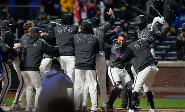 New York Mets center fielder Luis Robert Jr. (88) celebrates with teammates after hitting a three run home run during the eleventh inning of a baseball game against the Pittsburgh Pirates, Saturday, March 28, 2026, in New York. (AP Photo/Yuki Iwamura)