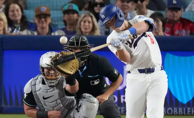 Los Angeles Dodgers' Will Smith, right, hits a two-run home run as Arizona Diamondbacks catcher James McCann watches during the eighth inning of a baseball game Saturday, March 28, 2026, in Los Angeles. (AP Photo/Mark J. Terrill)