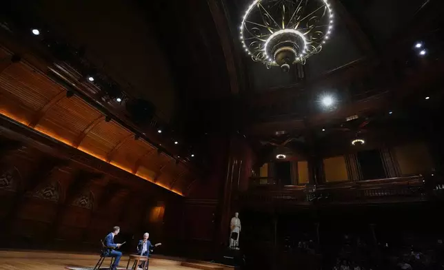 Federal Reserve Chair Jerome Powell, seated at right, gestures while addressing students with economics professor David Laibson at Harvard University, Monday, March 30, 2026, in Cambridge, Mass. (AP Photo/Charles Krupa)