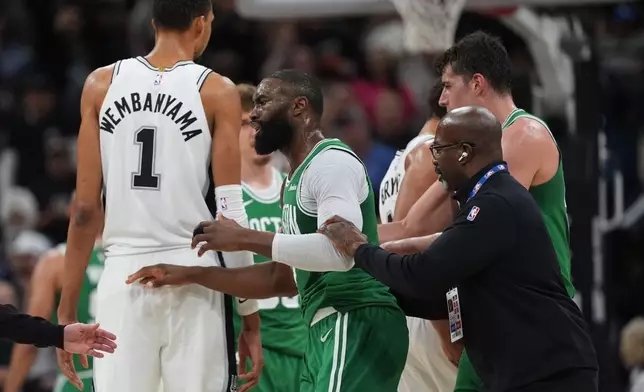Boston Celtics guard Jaylen Brown (7) is restrained as he argues a call during the first half of an NBA basketball game against the San Antonio Spurs in San Antonio, Tuesday, March 10, 2026. (AP Photo/Eric Gay)