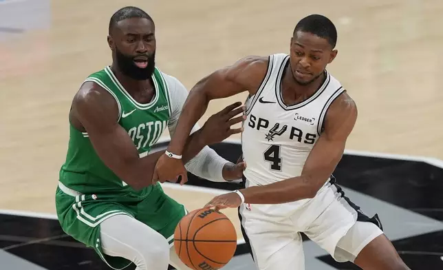 San Antonio Spurs guard De'aaron Fox (4) drives around Boston Celtics guard Jaylen Brown (7) during the first half of an NBA basketball game in San Antonio, Tuesday, March 10, 2026. (AP Photo/Eric Gay)