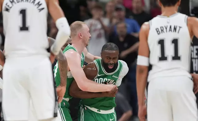 Boston Celtics guard Jaylen Brown (7) is restrained as he argues a call during the first half of an NBA basketball game against the San Antonio Spurs in San Antonio, Tuesday, March 10, 2026. (AP Photo/Eric Gay)