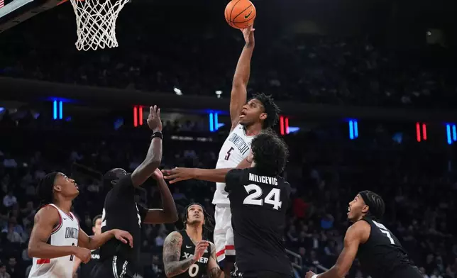 UConn's Tarris Reed Jr. (5) shoots over Xavier's Jovan Milicevic (24) during first half of an NCAA college basketball game in the quarterfinals of the Big East basketball tournament Thursday, March 12, 2026, in New York. (AP Photo/Frank Franklin II)