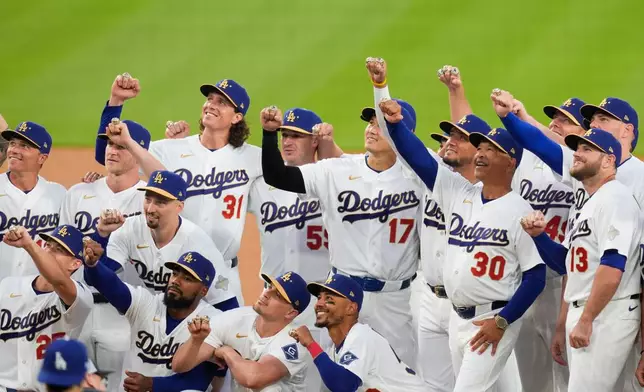Los Angeles Dodgers players hold up hands to show off their World Series Champion rings during a ceremony prior to a baseball game against the Arizona Diamondbacks in Los Angeles, Friday, March 27, 2026. (AP Photo/Caroline Brehman)