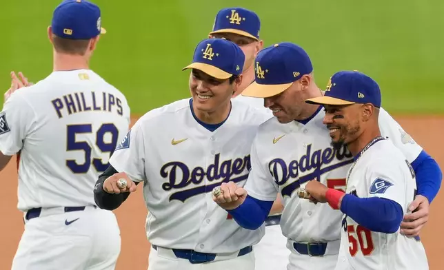Los Angeles Dodgers Shohei Ohtani, Freddie Freeman and Mookie Betts pose with their rings during a World Series Champion ring ceremony prior to a baseball game against the Arizona Diamondbacks in Los Angeles, Friday, March 27, 2026. (AP Photo/Caroline Brehman)