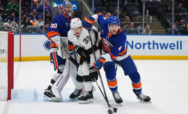 Los Angeles Kings' Jeff Malott (39) fights for position with New York Islanders' Carson Soucy (4) and goaltender Ilya Sorokin (30) during the third period of an NHL hockey game Friday, March 13, 2026, at UBS Arena in Elmont, N.Y. (AP Photo/Frank Franklin II)