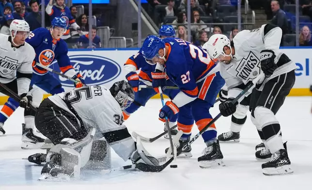 Los Angeles Kings goaltender Darcy Kuemper (35) and Cody Ceci (5) protects the net from New York Islanders' Anders Lee (27) during the second period of an NHL hockey game Friday, March 13, 2026, at UBS Arena in Elmont, N.Y. (AP Photo/Frank Franklin II)
