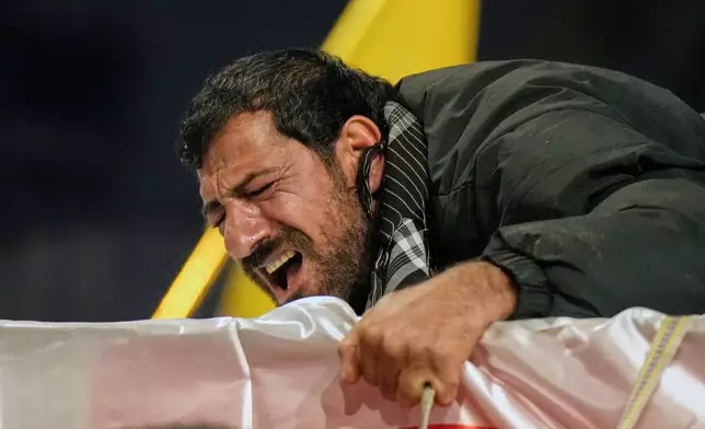 Relatives grieve in Baghdad, Iraq, on Thursday, March 12, 2026, during a funeral for members of the Popular Mobilization Forces who were killed in a U.S. airstrike in Qaim. (AP Photo/Hadi Mizban)