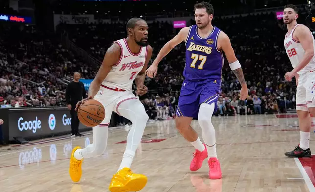 Houston Rockets' Kevin Durant (7) drives toward the basket as Los Angeles Lakers' Luka Doncic (77) defends during the first half of an NBA basketball game Wednesday, March 18, 2026, in Houston. (AP Photo/David J. Phillip)