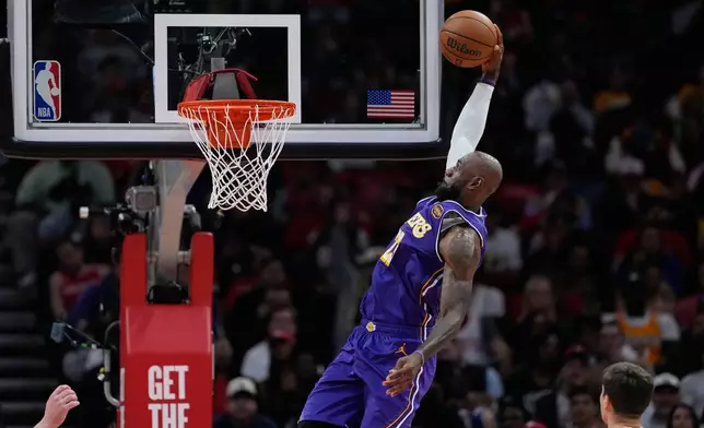 Los Angeles Lakers' LeBron James goes up for a dunk against the Houston Rockets during the first half of an NBA basketball game Wednesday, March 18, 2026, in Houston. (AP Photo/David J. Phillip)