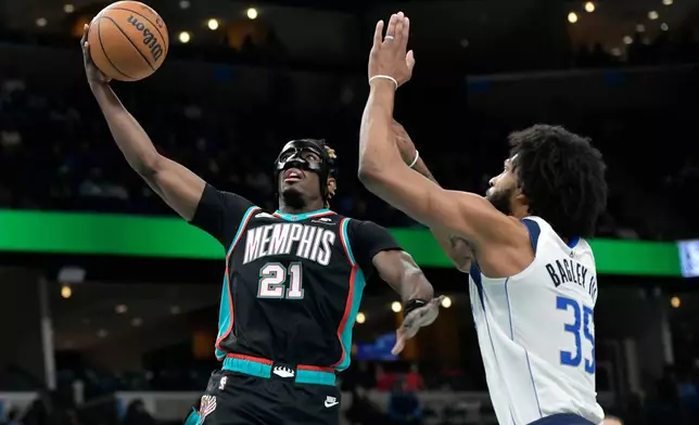 Memphis Grizzlies guard Jahmai Mashack (21) shoots against Dallas Mavericks forward Marvin Bagley III (35) in the first half of an NBA basketball game Thursday, March 12, 2026, in Memphis, Tenn. (AP Photo/Brandon Dill)
