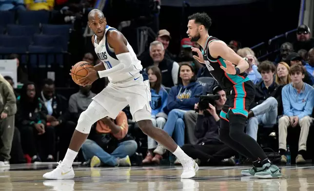 Dallas Mavericks forward Khris Middleton, left, handles the ball against Memphis Grizzlies forward Tyler Burton in the first half of an NBA basketball game Thursday, March 12, 2026, in Memphis, Tenn. (AP Photo/Brandon Dill)