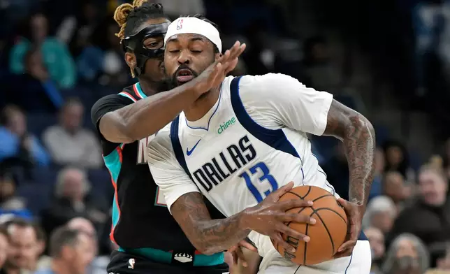 Dallas Mavericks forward Naji Marshall (13) handles the ball against Memphis Grizzlies guard Jahmai Mashack in the first half of an NBA basketball game Thursday, March 12, 2026, in Memphis, Tenn. (AP Photo/Brandon Dill)