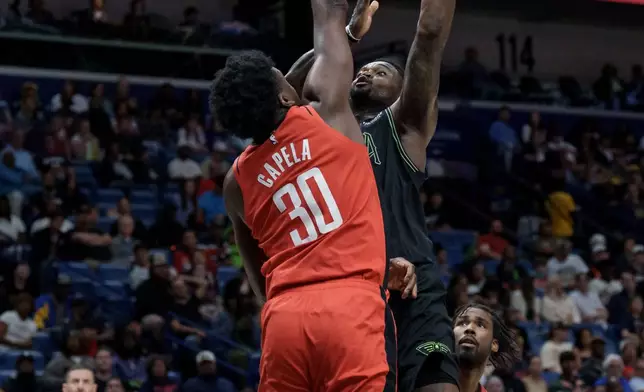 New Orleans Pelicans forward Zion Williamson (1) shoots against Houston Rockets center Clint Capela (30) during the second half of an NBA basketball game in New Orleans, Sunday, March 29, 2026. (AP Photo/Matthew Hinton)